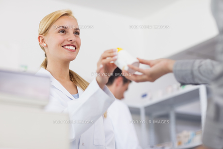 Pharmacist giving a drug box to a patient FYI00485311 Pharmacist giving a drug box to a patient FYI00485311