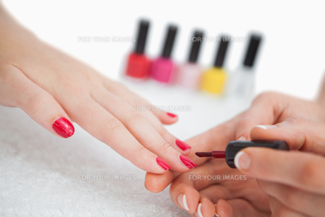 Woman applying nail varnish to finger nails FYI00488802 Woman applying nail varnish to finger nails FYI00488802